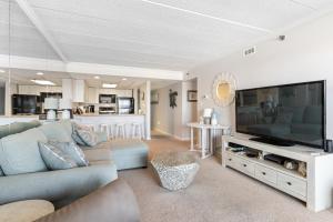 a living room with a couch and a large television at Bright Oceanfront 2BR Condo Balcony, King Bed & Parking in Ocean City