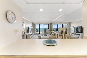a large living room with a clock on the wall at Bright Oceanfront 2BR Condo Balcony, King Bed & Parking in Ocean City