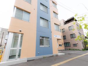 an apartment building with blue and orange at Tabist JKNツインホテル in Asahikawa