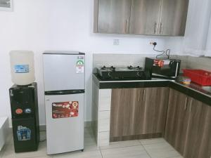 a kitchen with a stove and a refrigerator at Blerina House in Mombasa