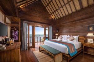 a bedroom with a large bed and a balcony at Pramana Nusa Ceningan in Nusa Lembongan