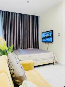 a bedroom with a bed and a couch and a television at Căn hộ Studio GH2 Vinhomes Grand Park in Long Bình