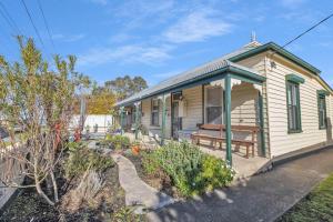 a small house with a bench in a garden at Cottswold in Paynesville