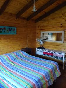 a bedroom with a bed in a wooden cabin at Don Gregorio in Empalme Lobos +24 photos