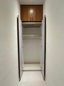 a walk in closet with a wooden cabinet at Casa Luma Canggu in Canggu +2 photos