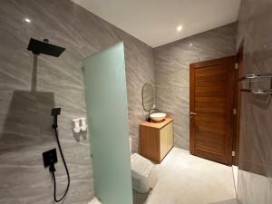 a bathroom with a shower with a sink and a toilet at Casa Luma Canggu in Canggu