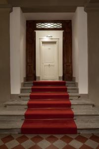 eine Treppe mit einer weißen Tür und einem roten Teppich in der Unterkunft Hotel Executive in Florenz