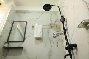 a bathroom with a shower with a white marble wall at Casa-Koker Residences in Kisumu