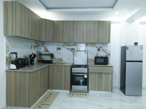 a kitchen with a stove and a refrigerator at Casa-Koker Residences in Kisumu +33 photos