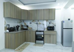a kitchen with wooden cabinets and a stove and refrigerator at Casa-Koker Residences in Kisumu