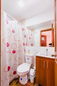 a bathroom with a toilet and a shower curtain at Hostal Doña Eliza in Bogotá +36 photos