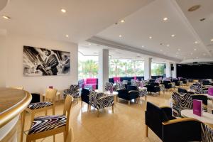 a restaurant with chairs and tables and a bar at Cala Millor Garden Hotel - Adults Only in Cala Millor