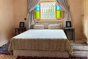 a bedroom with a large bed and a window at Dar Dahlia Atlas Valley in Oulad Akkou
