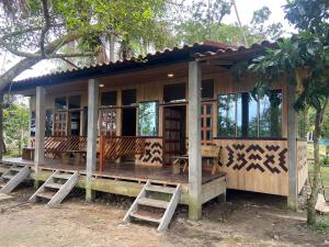 a wooden house with benches in front of it at Retazos Eco Hotel in Iquitos