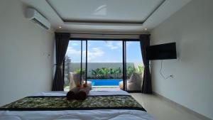 a bedroom with a bed with a view of a pool at Angkasa Sunrise Villa in Saba