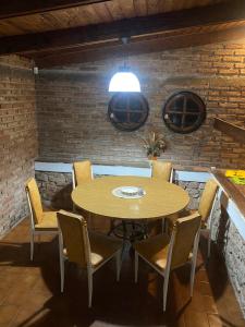 a table and chairs in a room with a brick wall at La casa de Pedro in San Roque