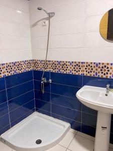 a blue and white bathroom with a sink and a shower at Corazón de la Ciudad in Tetouan +18 photos
