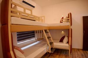 a room with two bunk beds and a window at Dune Homestay in Alleppey