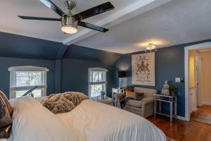a bedroom with blue walls and a ceiling fan at The Maple House Fully Fenced-in Yard! in Saugatuck