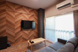 a living room with a couch and a flat screen tv at Hotel ROI 博多 in Fukuoka