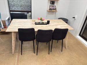 a wooden table with four chairs in a room at One bedroom with breakfast in Auckland