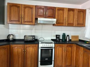 una cucina con mobili in legno e un forno a piano cottura di Joes House- cerca al mall real plaza a Cuzco Altre 13 foto