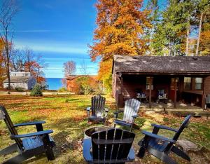 un groupe de chaises assises devant une maison dans l'établissement Cozy Cottage Lake Access Fire Pit, à Sodus