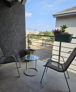 a patio with two chairs and a glass table on a balcony at Blue sky in Komé