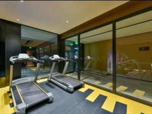 una palestra con due tapis roulant e specchi di Beijing Guomao Business District Sihui Orange Crystal Hotel a Pechino