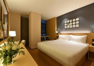 una camera d'albergo con un grande letto bianco e un tavolo di Beijing Guomao Business District Sihui Orange Crystal Hotel a Pechino