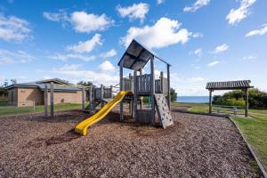 un patio de recreo con un tobogán en un parque en Ipanema with spa and moments from the beach, en Safety Beach