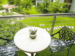 a white table and chairs on a balcony with a plant at Menlyn Maine Residences - Napoli with king sized bed in Pretoria +39 photos