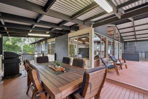 霍尔斯加普Mountain Hideaway by Halls Gap Accommodation的甲板上的木制餐桌和椅子