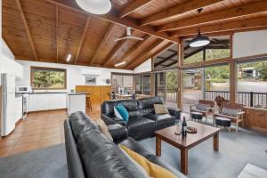 霍尔斯加普Mountain Hideaway by Halls Gap Accommodation的客厅里有一张沙发和一张桌子。 更多12张照片