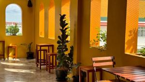un restaurante con mesas y sillas y una maceta en Baan PadSeeEw - Rooftop Riverview 2nd floor, en Thonhuri