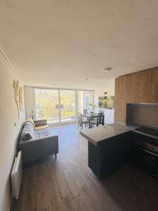 eine Küche und ein Wohnzimmer mit einer Couch und einem Tisch in der Unterkunft Departamento vista cordillera alto la florida in Santiago