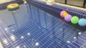 a pool with colorful balls on the side of it at Daebudo Nurimaru Pension in Ansan