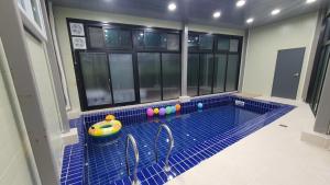 a small swimming pool in a room with windows at Daebudo Nurimaru Pension in Ansan