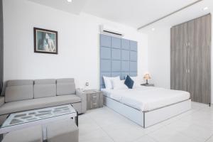 a white bedroom with a bed and a couch at White Diamond Hotel in Ho Chi Minh City