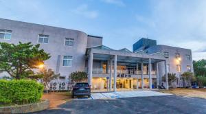 Shih-men川赋会馆-石门山劳工育乐中心的一栋建筑前停着一辆车