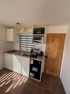 a small kitchen with a sink and a stove at Cabaña en Vallenar in Vallenar +10 photos