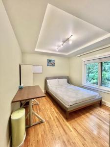 Un dormitorio con una cama y una mesa y una ventana. en Luxuary Stay in West Vancouver, en West Vancouver