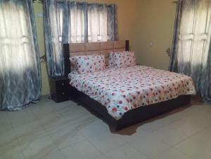 a bedroom with a bed with pillows and curtains at GA guest House in Ibadan