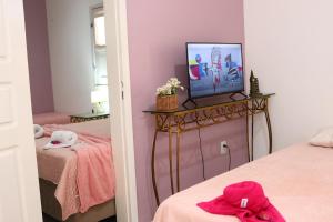 a room with two beds and a television on a table at Casa no Jardim Renascença- Bird House Renascença in São Luís