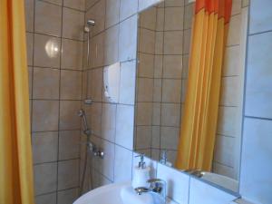 a bathroom with a sink and a shower with a mirror at Hotel Leon in Biała Podlaska