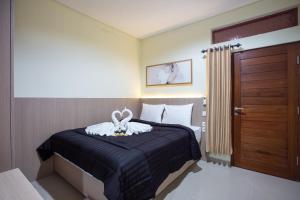 a bedroom with a bed with a rabbit on it at Opang Asri Guesthouse Sanur in Sanur +8 photos