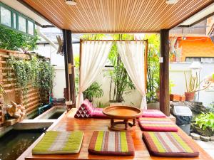 a patio with a table and four pillows on a table at Pao Come Boutique House in Chiang Mai