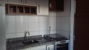 uma cozinha com um lavatório e um fogão forno superior em Flat Studio Iracema apto 602 em Fortaleza