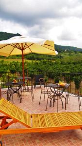 a patio with tables and chairs and an umbrella at La luna nel fiume in Giffoni Valle Piana