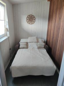 a bedroom with a bed with white sheets and pillows at Altana Kasztelana - Domek Letniskowy z tarasem i jacuzzi nad Dunajcem Velo in Wojnicz